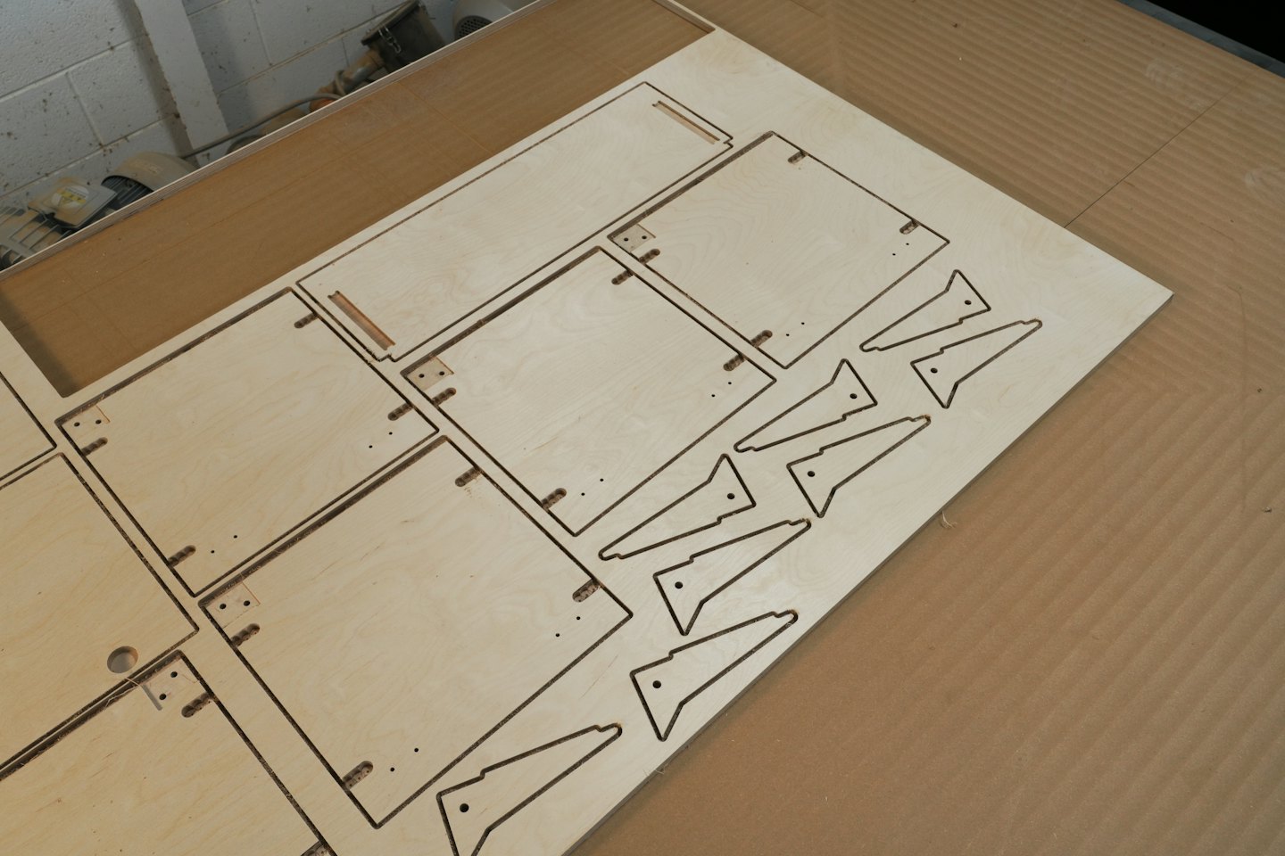 Laser cut plywood sheet with geometric patterns on a table.