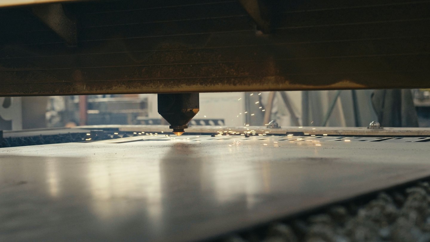 Laser cutting machine actively cutting sparks from metal.